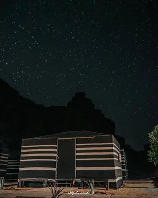 a building under a starry sky at night at Rum Sky Experiences in Wadi Rum