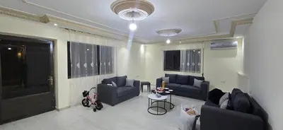 a living room with two blue couches and a table at الريان غرفتين نوم in Amman