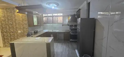 a kitchen with a black refrigerator and a counter at الريان غرفتين نوم in Amman