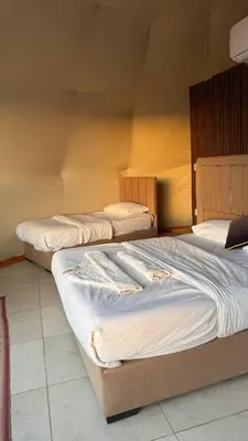 two beds sitting in a room with at Tarf Wadi Rum Luxury Camp & Jeep Tours in Wadi Rum