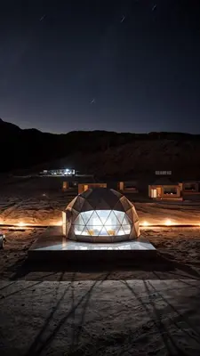 a building with a glass dome at night at Tarf Wadi Rum Luxury Camp & Jeep Tours in Wadi Rum