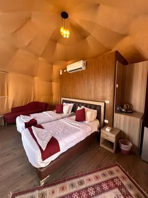 a bedroom with a large bed in a room with a ceiling at Moon Dunes Wadi Rum in Disah