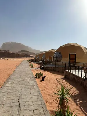 a row of tents in the desert next to a road at Moon Dunes Wadi Rum in Disah