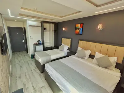 a hotel room with two beds and a television at Holiday Season Hotel in Aqaba