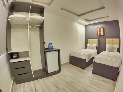 a small room with two beds and a mirror at Holiday Season Hotel in Aqaba