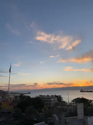 a view of the ocean from a city at sunset at Holiday Season Hotel in Aqaba