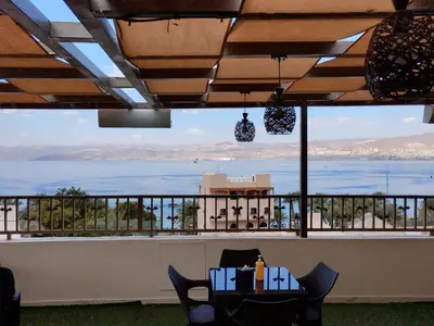 a view of the ocean from a balcony with a table and chairs at Holiday Season Hotel in Aqaba