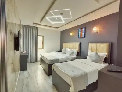 a hotel room with two beds and a television at Holiday Season Hotel in Aqaba