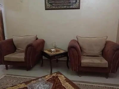 a living room with two chairs and a coffee table at رحيق الزخور هاوس in Madaba