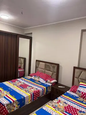 a bedroom with two beds and a mirror at الاغوار bb in Khirbat ash Shaykh Muḩammad
