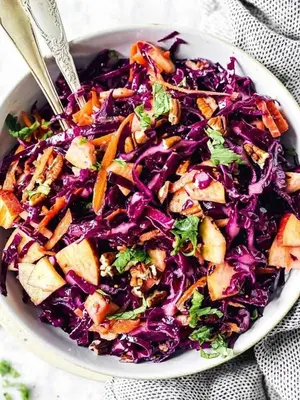 a white bowl filled with a salad with cabbage and carrots at الاغوار bb in Khirbat ash Shaykh Muḩammad