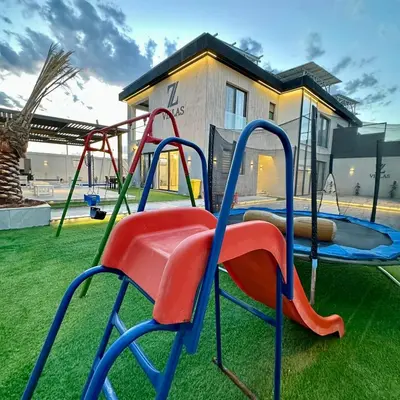 a playground with a slide in a yard at Z villas Chalet in Al Rama