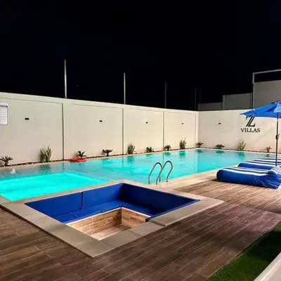 a large swimming pool with a large blue poolvisor at Z villas Chalet in Al Rama