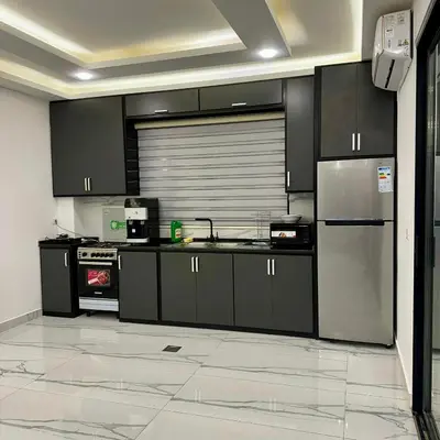 a kitchen with black cabinets and stainless steel appliances at Z villas Chalet in Al Rama