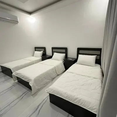 three beds in a room with white walls at Z villas Chalet in Al Rama