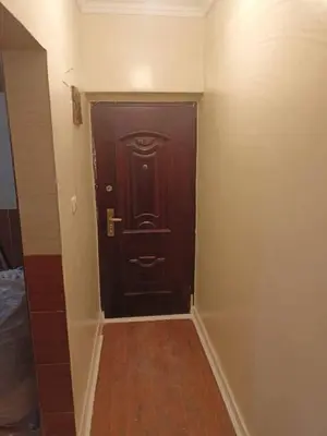a dark wooden door in a room with a hallway at ريمون هاوس in Kafr Khall