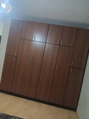 a large closet with brown cabinets in a room at ريمون هاوس in Kafr Khall