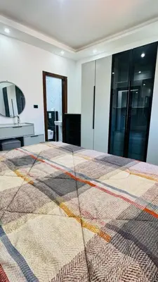 a bedroom with a large bed with a colorful quilt at شقق فاخره للايجار in Amman