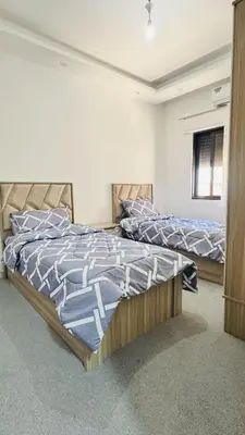 a bedroom with two beds and a window at شقق فاخره للايجار in Amman