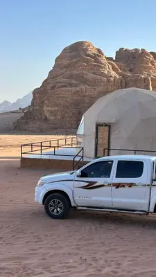 a white truck parked in front of a tent at Kadi Wadi Rum in Al Jafr