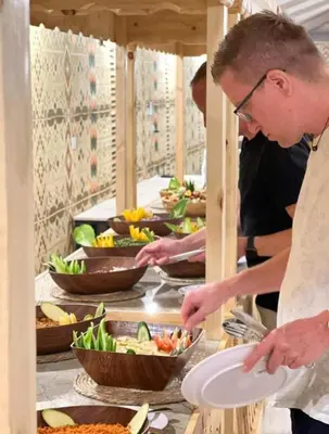 a couple of people preparing food in a buffet at wadi rum luxury bubble soul in Wadi Rum