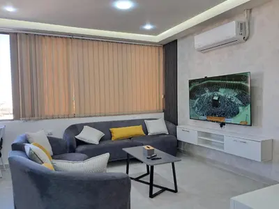 a living room with a blue couch and a tv at منزل السعادة in Amman