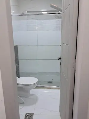a bathroom with a toilet and a glass shower at منزل السعادة in Amman