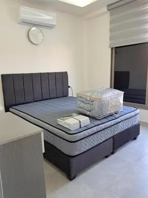 a bed sitting in a room with a table at منزل السعادة in Amman