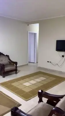 a living room with a tv and a couch and a rug at مليح هوستل