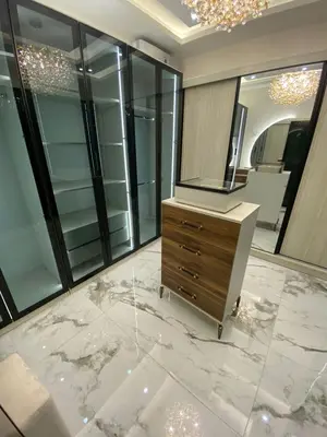 a bathroom with a dresser and a large mirror at Sanad Apartment شقة فندقية in Aqaba