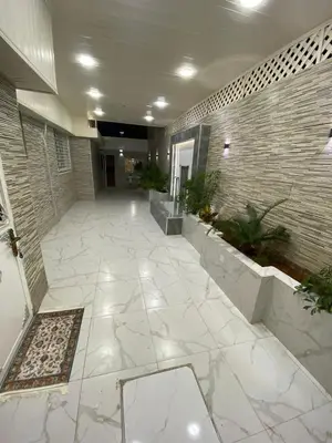 a large lobby with a large tile wall and a hallway at Sanad Apartment شقة فندقية in Aqaba