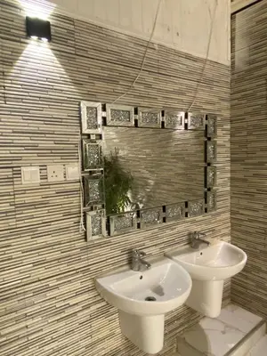 a bathroom with two sinks and a mirror at Sanad Apartment شقة فندقية in Aqaba