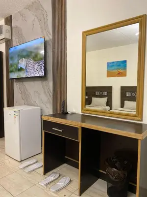 a desk with a mirror and a television on a wall at Eden Hotel in Aqaba