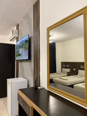 a large mirror in a room with a bedroom at Eden Hotel in Aqaba