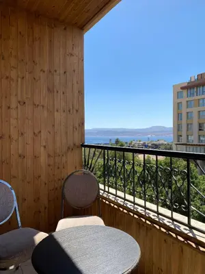 a balcony with two chairs and a table and a view at Eden Hotel in Aqaba