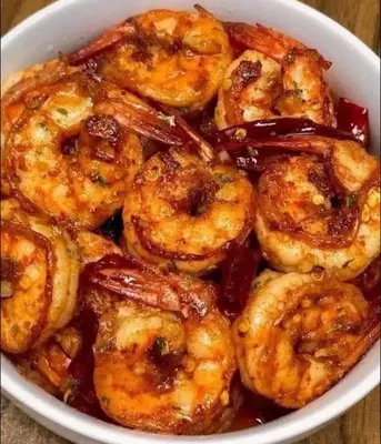 a bowl of shrimp with sauce on a table at وادي الشلاله هاوس in Al Mughayyir