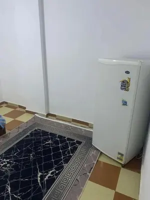 a room with a refrigerator and a tile floor at وادي الشلاله هاوس in Al Mughayyir