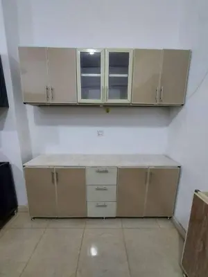 a kitchen with white cabinets and a counter top at وادي الشلاله هاوس in Al Mughayyir