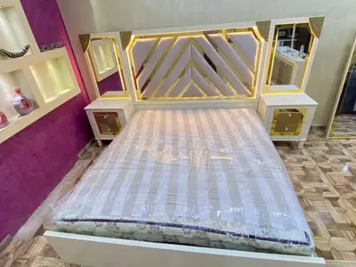 an empty bed in a room with purple walls at وادي الشلاله هاوس in Al Mughayyir