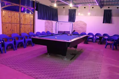 a room with a pool table and chairs at استراحة ومنتجع قرية الزرب in Ajloun
