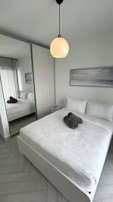 a bedroom with a large white bed with a hat on it at Ayla Aqaba Azure 2 bedroom in Aqaba