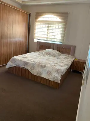 a bedroom with a large bed in a room with a window at شاليه جبال سوف in Jerash