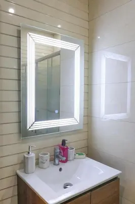 a bathroom with a white sink and a mirror at Rams Der Ghbar 3BR cozy Apt in Amman