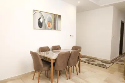 a dining room with a table and chairs at Rams Der Ghbar 3BR cozy Apt in Amman