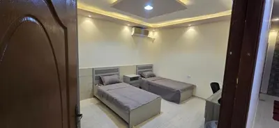 a small room with two beds and a table at الريان in Amman