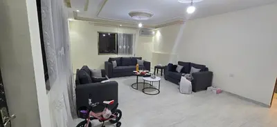 a living room with blue couches and a table at الريان in Amman