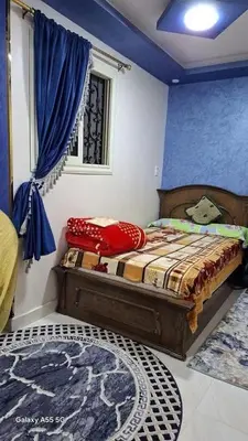 a bedroom with a bed in a room with blue walls at الزواهره هاوس in Az Zarqa