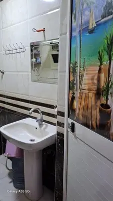 a bathroom with a sink and a painting on the wall at الزواهره هاوس in Az Zarqa
