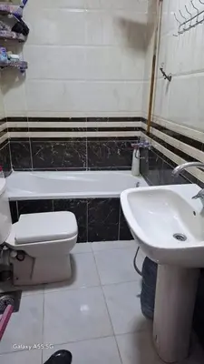 a bathroom with a sink and a toilet and a tub at الزواهره هاوس in Az Zarqa