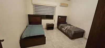 two beds in a small room with a window at شقة مفروشة في طبربور 3 غرف نوم in Amman